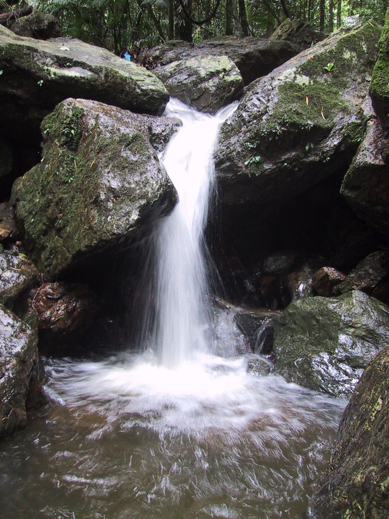 Waterfall cascading over granite boulders in the Red Peak rainforest